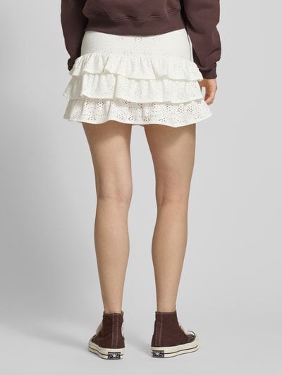 Männermodel trägt Leicht ausgestellter Mini-Skort mit Lochstickerei Modell 'SMILLA' von Only, efekt: jednolity kolor, faktura, długość mini, haft angielski, falbany, elastyczny tunel w pasie, dół obszyty falbaną, Ganzkörperansicht Rückansicht.
