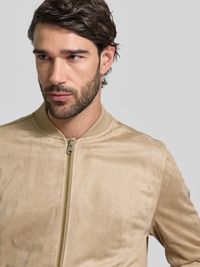Männermodel trägt Regular Fit Jacke in Leder-Optik Modell 'Rapid' von CINQUE, beige, sichtbarer Zweiwege-Reißverschluss, Nahaufnahme Oberkörper.