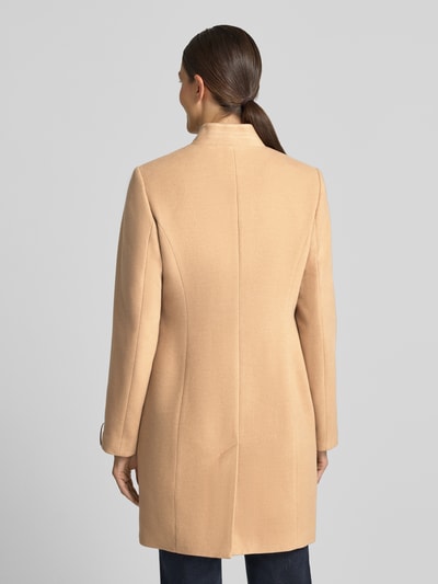 Frauenmodel trägt Mantel mit Viskose-Anteil von COMMA in hellem Beige, taillierte Passform, Stehkragen, glatte Textur, Ganzkörperansicht Rückansicht. Kontext: Elastischer Material-Mix, Knopfverschluss, Rückenlänge 90 cm, Schulterbreite 38 cm, Brustweite 47 cm, Ärmellänge 64 cm.