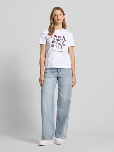 Frauenmodel trägt Damen T-Shirt von Only, Modell 'KITA', Optik: Unifarben, Motiv-Print mit Pailletten, Slim-Fit, Rundhals, Kurzarm, Jersey aus reiner Baumwolle, Ganzkörperansicht von vorne.