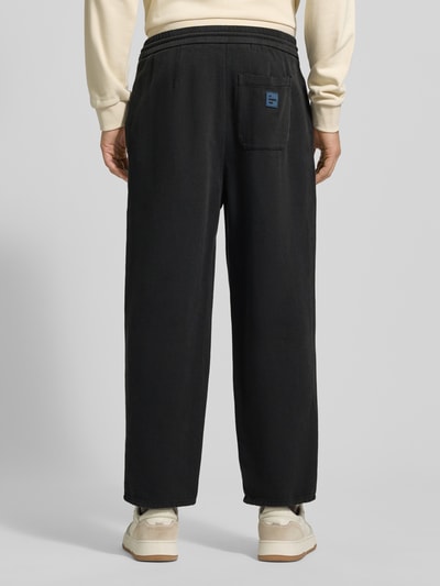 Männermodel draagt Flared Sweatpants met tunnelkoord Model 'AFAZ' van American Vintage, puur katoen, heren, flared cut, binnenbeenlengte maat M 69 cm, elastische band, effen zwart, Ganzkörperansicht Rückansicht.