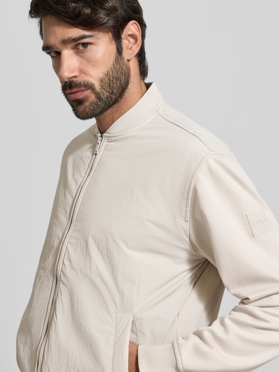 Männermodel trägt Regular Fit Bomberjacke mit Baumwoll-Anteil Modell 'ZE_SMARTCORE' van BOSS Orange, beige, unifarben, Nahaufnahme Oberkörper.