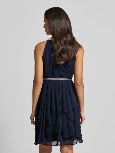 Frauenmodel trägt Cocktailkleid mit Nahtreißverschluss von Jake*s Cocktail in Dunkelblau, taillierter Schnitt, blickdichtes Unterkleid, Rückenlänge 92 cm, Brustweite 33 cm, Ganzkörperansicht Rückansicht.