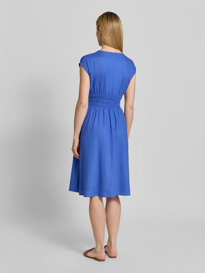 Modelka nosi 'Knielanges Kleid aus Leinen-Mix mit Knopfleiste' od Christian Berg Woman Selection, niebieski len z wiskozą, krój taliowany, długość do kolan, dekolt V, guziki, rękaw typu kappa, smokowanie, długość tyłu w rozmiarze 36: 44 cm, szerokość w rozmiarze 36: 44 cm, widok całej sylwetki z tyłu.