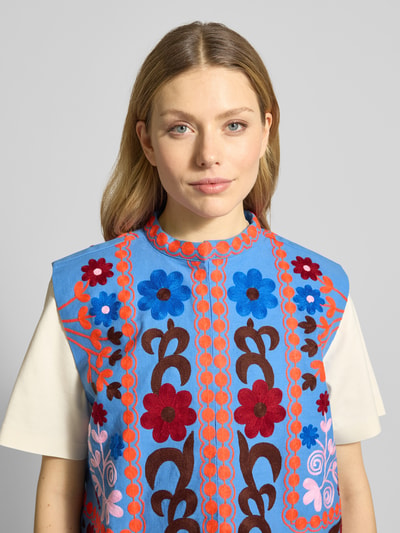 Frauenmodel trägt Weste mit Stitchings Modell 'Bin' von Lollys Laundry in Blau mit farbigen Blumenmustern, Reine Baumwolle, Regular-Fit, Nahaufnahme Oberkörper.