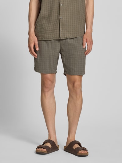 Männermodel trägt Regular Fit Shorts aus Viskose-Leinen-Mix Modell 'TEL LATHAM' von Only & Sons in unifarbener Optik mit Strukturmuster, elastischem Bund und seitlichen Eingrifftaschen, Ganzkörperansicht von vorne.