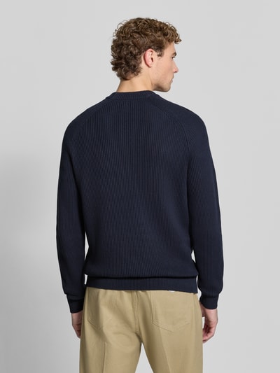 Männermodel trägt donkerblau Regular fit pullover van puur katoen Model 'Hellson' van Matinique met tricotlook, elastische boordjes, ruglengte maat M 75 cm, mouwlengte maat M 88 cm, heren pullover, gebreide textuur, beige broek, ganzkörperansicht rückansicht.