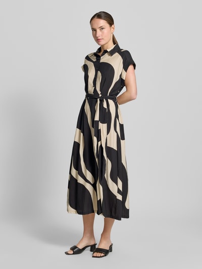 Frauenmodel trägt Hemdblusenkleid mit Bindegürtel Modell 'NIKITA' von Mango aus Viskose-Mix, Taillierter Schnitt, Schwarz-Beige, Ganzkörperansicht von vorne.