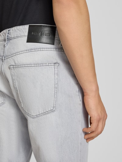Mężczyznamodel nosi Straight Fit Jeans aus reiner Baumwolle Modell 'EDGE' von Only & Sons, jasnoszary denim, label patch, 5 kieszeni, detalaufnahme tyłów.
