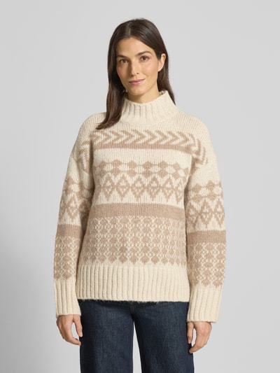 Frauenmodel trägt Comfort Fit Strickpullover aus Norweger-Strick Modell 'AMPLE' von Vero Moda, Optik:Allover-Muster, Stehkragen, Langarm, Ärmelabschluss gerippt, Rumpfabschluss gerippt, Materialverarbeitung: Strick, Farben Creme und Beige, Muster geometrisch, weiche Textur, Ganzkörperansicht von vorne.