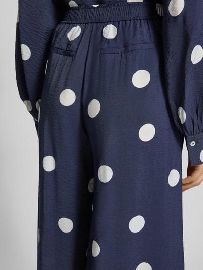 Frauenmodel trägt Stoffhose aus Viskose-Mix mit elastischem Bund von Christian Berg Woman, Allover-Look, Regular-Fit, Detailaufnahme Rückansicht.