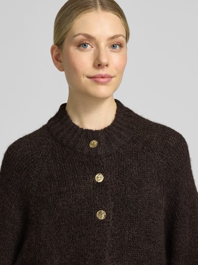 Vrouwenmodel draagt donkerbruin gebreid jack van Neo Noir, katoenmix, relaxed fit, ronde hals, knoopsluiting, 3/4-mouw, model 'Benutta', Nahaufnahme Oberkörper.