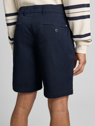 Männermodel trägt Chinoshorts aus Baumwoll-Mix Modell 'DOVER' von Tommy Hilfiger, Optik: Unifarben, Passform: Regular-Fit, Paspeltaschen und Knopf, Ganzkörperansicht Rückansicht.