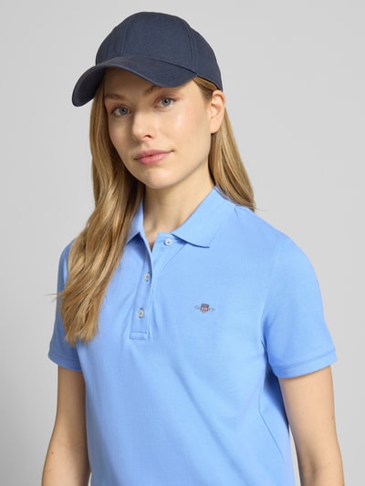 Frauenmodel trägt Poloshirt mit Logo-Stitching und Polokragen von Gant in Blau aus Reine Baumwolle, Regular-Fit, Nahaufnahme Oberkörper.