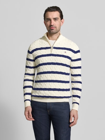 Männermodel trägt Slim Fit Pullover in Strick-Optik von Gant, reine Baumwolle, Troyer-Kragen, Logo-Stitching, navy-weiße Streifen, ganzkörperansicht von vorne