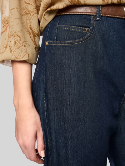 Vrouwenmodel draagt Straight Fit Jeans aus elastischem Baumwoll-Mix van Marc Cain in donkerblauw katoenmix met riemlussen, 5-pocketmodel, knoop- en ritssluiting, bandwijdte maat 36: 37 cm, binnenbeenlengte maat 36: 73 cm, detailopname linkerheup.