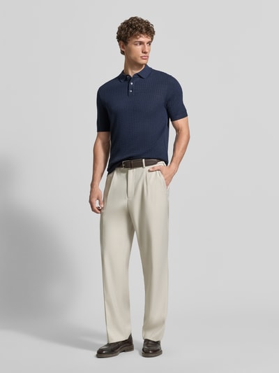 Männermodel trägt Slim Fit Poloshirt in Strick-Optik Modell 'Vanceo' von JOOP! Collection, Reine Baumwolle, dunkelblau, Ganzkörperansicht von vorne.