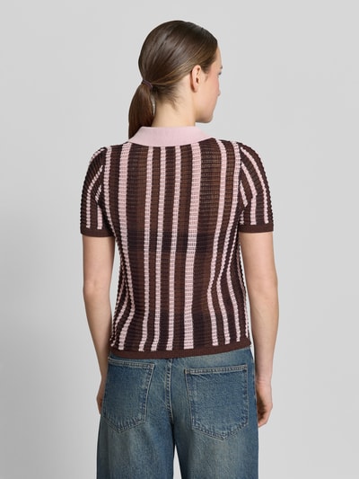 Frauenmodel trägt Modern Fit Poloshirt in Strick-Optik Modell 'PETRA' von Mango, braun-rosafarbene Streifen, Baumwoll-Mix, Ganzkörperansicht Rückansicht. Rückenlänge bei Größe S: 53 cm, Ärmellänge bei Größe S: 23 cm, Polokragen, kurze Knopfleiste.