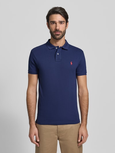 Männermodel trägt Slim Fit Poloshirt mit Logo-Stitching von Polo Ralph Lauren, Reine Baumwolle, Unifarbenes Design, Polokragen, Ganzkörperansicht von vorne.