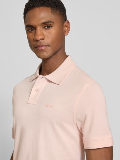 Männermodel trägt Regular Fit poloshirt aus zuiver katoen Modell 'PRIME' van BOSS Orange, look: effen, piqué, korte mouw, labelapplicatie, polokraag, V-hals, korte knoopsluiting, nahaufnahme bovenlichaam.