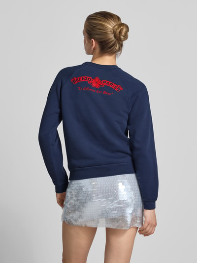 Vrouwenmodel draagt Regular Fit pullover met logo-stitching van Kenzo in donkerblauw, puur katoen, ronde hals, elastische boordjes, ruglengte bij maat S 55 cm, volledige lichaamsaanzicht achteraan.