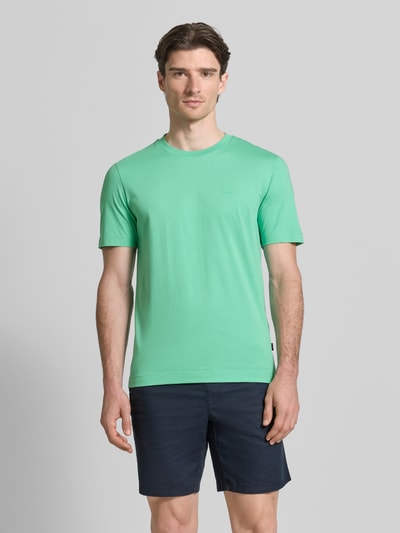 Männermodel trägt Regular Fit T-Shirt aus reiner Baumwolle Modell 'Thompson 01' von BOSS in Mintgrün, unifarben, Rundhals, Ganzkörperansicht von vorne.