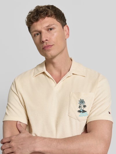 Männermodel trägt Regular Fit Poloshirt aus Frottee von Tommy Hilfiger in Beige mit Polokragen und Brusttasche, Nahaufnahme Oberkörper