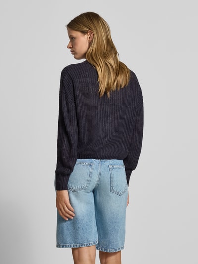 Vrouwenmodel draagt donkerblauw gebreid jack met v-hals, grove textuur, lichte denim short, Boxy Fit Strickjacke mit V-Ausschnitt model 'CAROL' van ONLY, Dames, volledige achteraanzicht