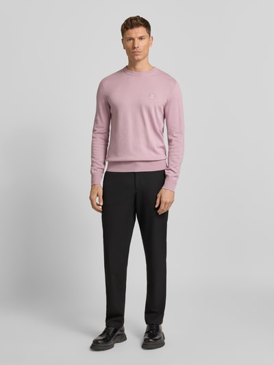 Männermodel trägt Regular Fit Pullover aus katoen-kasjmiermix Modell 'KANOVANO' van BOSS Orange, effen lichtroze, lange mouwen, label patch, ronde hals, geribde boorden, struc-knit, unicolor, ganzlichaamsaanzicht van voren.