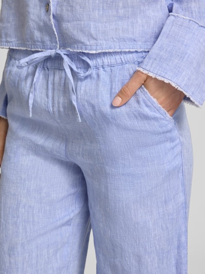 Frauenmodel trägt Leinenhose mit elastischem Bund und Tunnelzug von Christian Berg Woman in Hellblau, reine Leinen, Nahaufnahme Oberkörper.