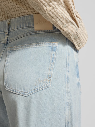 Frauenmodel trägt Relaxed Fit Barrel Jeans aus reiner Baumwolle Modell 'BALOON HR 1.0' von BOSS Orange in Denim-Optik mit Gesäßtasche, Nahaufnahme Hüfte.