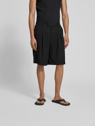 Männermodel trägt schwarze Shorts mit Viskose-Anteil von Don’t Waste Culture, Relaxed Fit, teilelastischer Bund, Ganzkörperansicht von vorne.