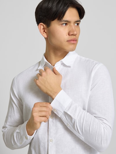 Männermodel trägt Slim Fit Freizeithemd aus Baumwoll-Leinen-Mix Modell 'CAIDENLS SOLID' von Only & Sons, unifarben, Nahaufnahme Oberkörper.