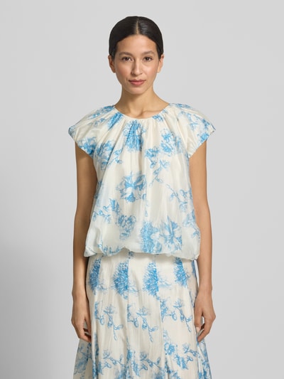 Frauenmodel trägt Regular Fit Bluse aus Lyocell-Mix Modell 'Evangelia' von MSCH Copenhagen, floraler Allover-Print, Falten-Optik, hellblau auf cremeweiß, kurzärmelig, Rückenlänge bei Größe S 50 cm, Ganzkörperansicht von vorne.