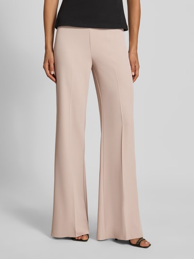 Vrouwenmodel draagt Flared Fit broek met bandplooien van Rinascimento in lichtroze, elastische materiaalmix, naadritssluiting, Binnenbeenlengte maat S 85 cm, Bandwijdte maat S 37 cm, comfortband, flared fit, Ganzkörperansicht von voren