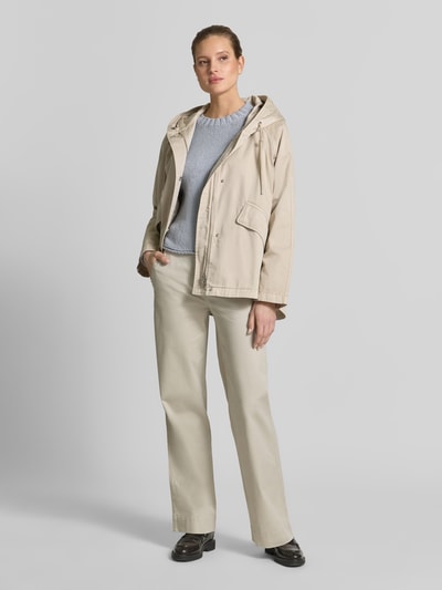Frauenmodel trägt Regular Fit Jacke aus reiner Baumwolle von Marc O'Polo in Beige mit Kapuze, Druckknöpfen und Pattentaschen, Ganzkörperansicht von vorne.