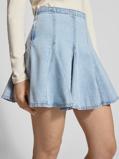 Modelka kobieca nosi Jeansrock mit Falten Modell 'GODET' od Levi's®, jasnoniebieski, bawełna z lyocellem, linia A, minispódnica; Szerokość w rozmiarze 27: 40 cm, Długość całkowita w rozmiarze 27: 38 cm, widok z przodu, ujęcie zbliżeniowe na dolną część ciała.