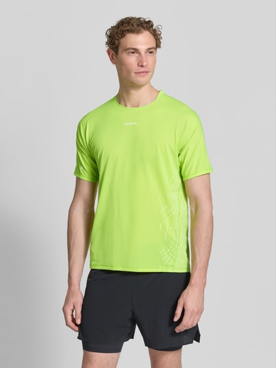 Männermodel trägt Funktionsshirt mit Logo Modell 'SENSE AERO' von Salomon in leuchtendem Grün, Regular Fit, Rundhalsausschnitt, Ganzkörperansicht von vorne.