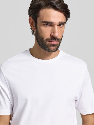 Männermodel trägt T-Shirt mit Logo-Stitching von HECHTER PARIS in Weiß, reine Baumwolle, gerader Schnitt, Nahaufnahme Oberkörper.