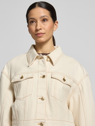 Frauenmodel trägt Regular Fit Jeansjacke aus reiner Baumwolle Modell 'GISOLIA' von HUGO in heller Denim-Optik mit Umlegekragen, einreihiger Knopfleiste, Label-Patch, Langarm, dekorativen Knöpfen, Brusttaschen, Nahaufnahme Oberkörper.