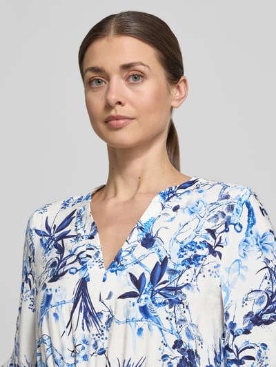 Frauenmodel trägt Midikleid aus Viskose-Mix im Allover-Look von ROBE LÉGÈRE, blau-weiß gemustert, V-Ausschnitt, Nahaufnahme Oberkörper.