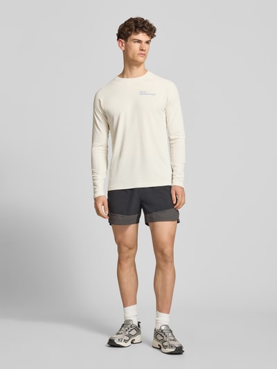 Mannenmodel draagt shirt met lange mouwen met labelprint model 'SORONA' van HALO, regular fit, ronde hals, ruglengte maat M 66 cm, volledige lichaamsaanzicht van voren