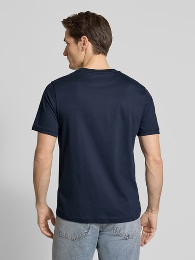 Männermodel trägt Regular Fit T-Shirt aus reiner Baumwolle Modell 'BRAND LOVE TEXT' von Tommy Hilfiger, unifarben, Ganzkörperansicht Rückansicht.