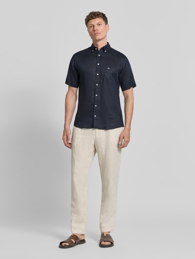 Männermodel trägt Regular Fit Leinenhemd mit Button-Down-Kragen von Fynch-Hatton in Dunkelblau, sichtbare Brusttasche, Ganzkörperansicht von vorne, reines Leinen, Rückenlänge 75 cm bei Größe M, Schulterbreite 44 cm, Ärmellänge 27 cm.