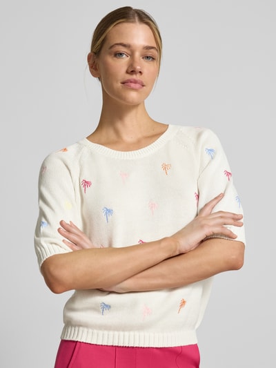 Kobiece model prezentuje Pullover mit Raglanärmeln und Motiv-Stitching von Smith and Soul, kremowy bawełniany sweter z krótkim rękawem, prosty krój, okrągły dekolt, raglanowe rękawy, motyw haftu, ściągacze, długość pleców w rozmiarze S: 48 cm, długość rękawa w rozmiarze S: 34 cm, kolorowe detale, widok całej sylwetki z przodu