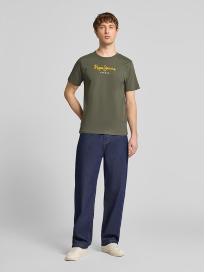 Männermodel trägt Regular Fit T-Shirt aus reiner Baumwolle Modell 'EGGO' von Pepe Jeans, Optik: Unifarben, Label-Print, Rundhals, Kurzarm, Jersey; Ganzkörperansicht von vorne.