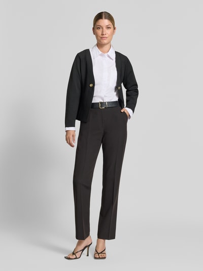Frauenmodel trägt schwarzen Cardigan mit Zierknöpfen Modell 'APOLLO' von MANGO, gerader Schnitt, V-Ausschnitt, Ganzkörperansicht von vorne