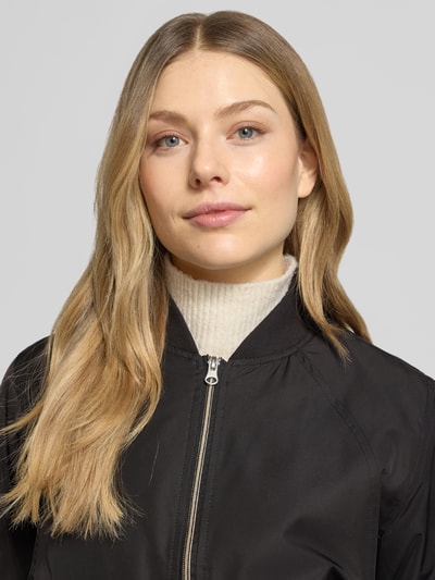 Frauenmodel trägt Regular Fit Jacke mit Stehkragen Modell 'Zaymi' von CARS JEANS, mit Reißverschluss und Eingrifftaschen, Nahaufnahme Oberkörper. Rückenlänge 61 cm, Schulterbreite 41 cm, Brustweite 39 cm, Ärmellänge 60 cm, schwarze glatte Struktur, elastische Abschlüsse.