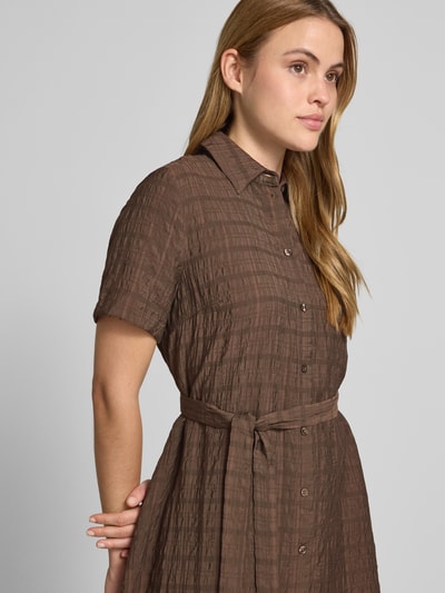 Vrouwenmodel draagt Hemdblusenkleid aus Viskose-Lyocell-Mix mit Bindegürtel van Jake*s Casual in bruine A-lijn met structuurpatroon, hemdkraag en knielengte, detailopname bovenlichaam.