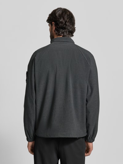 Männermodel trägt Regular Fit Blouson mit Raglanärmeln von s.Oliver BLACK LABEL in dunklem Melange, elastische Abschlüsse, Ganzkörperansicht Rückansicht.